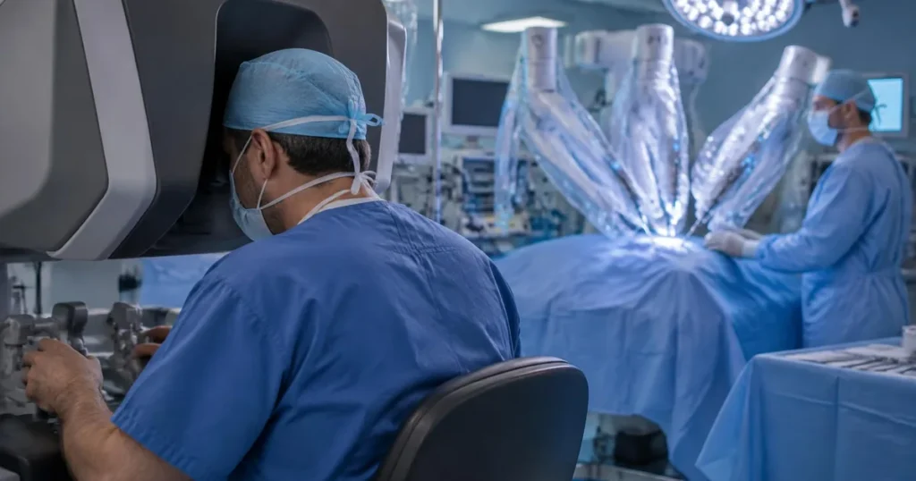 Robô cirúrgico com braços mecânicos e console em sala de cirurgia urológica